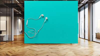 White earphones on blue background Wall mural