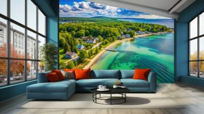 Sandy shoreline and crystal-clear waters of Little Traverse Bay, surrounded by lush greenery and picturesque villages, evoke a sense of serene tranquility. Wall mural