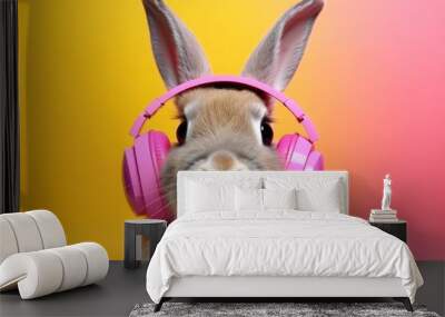 Cheerful fluffy bunny in pink headphones on pink background. Creative layout with rabbit, spring, easter holiday, funny minimalistic card with animal Wall mural