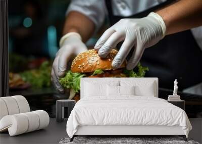 Chef's hands in gloves prepare a delicious hearty hamburger in the kitchen of a cafe or restaurant. Close-up cooking fast food, burger, cheeseburger Wall mural