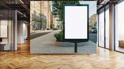 Vertical blank glowing billboard on the city street. In the background buildings and road with cars. Mock up. The poster on the street next to the roadway. Wall mural