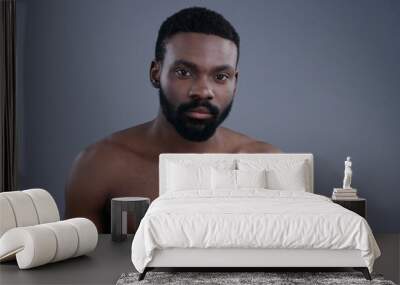 Close-up portrait of attractive bearded african american man on grey background. Beautiful black young man looking at camera. Wall mural