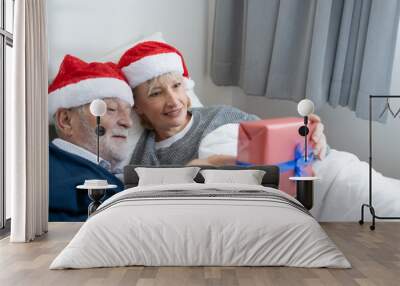 senior elderly caucasian old man give gift presents to woman, they happy together in bedroom for christmas festival day in the morning, retirement lovely couple lifestyle concept Wall mural