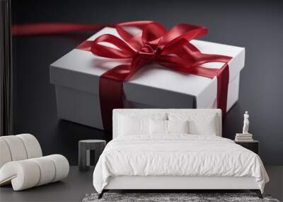 Gift box and red ribbon on black background Wall mural