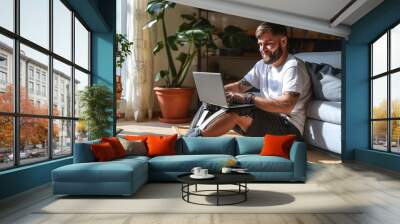 Happy young man with disability leg prosthesis sitting on floor at home using laptop computer working or elearning, browsing web, searching online. People with amputation disabilities, Generative AI Wall mural