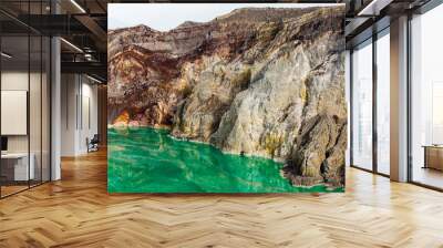 Shot of the shore of a green sulfur lake in the crater of the Kawah Ijen volcano in Indonesia. Mountain landscape Wall mural