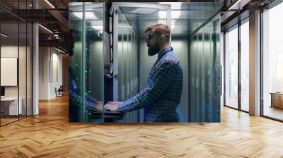 Bearded IT specialist setting servers in data center Wall mural