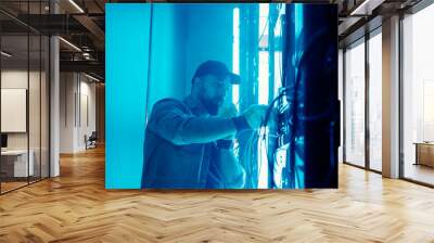 Bearded man repairing LED monitor in smoke Wall mural