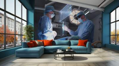 Doctors perform surgery in hospital operating room wearing AR headsets. 3D graphics of virtual AI holographic display showing vital signs and patient condition. VFX animation. Modern medicine concept. Wall mural