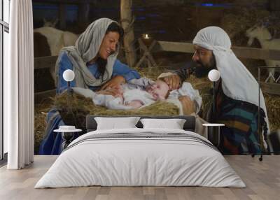 Mary and Joseph taking care of baby Jesus in inn stable Wall mural