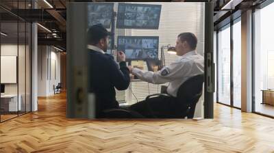 Two security guards talk, have lunch while control CCTV cameras on computers. Software showing footage of surveillance cameras with scanning system on screens. High tech security concept. Slow motion. Wall mural