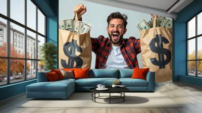 Man celebrating with bags of money, expressing joy and financial success. Wall mural