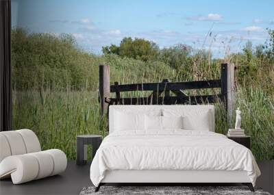 Wooden entry fence to pasture in high grass Wall mural