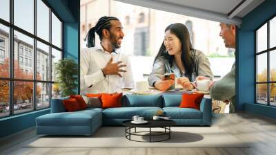 Positive colleagues having coffee and communicating during break Wall mural