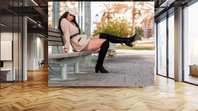 Stylish Caucasian woman sitting on the bench and posing Wall mural