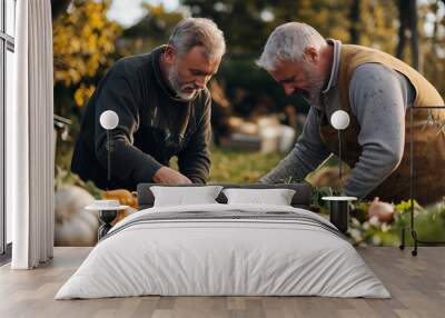 Elderly farmers inspecting a compost pile in their vegetable garden on a bright autumn day Wall mural