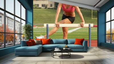 Young Woman in Sports Bra Warming-up on Hurdle Wall mural