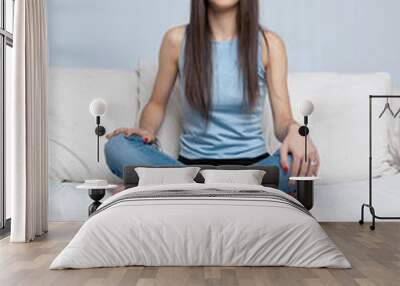 Brunette cross-legged on a sofa Wall mural