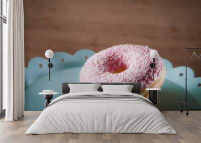 Pink donut on turquoise plate Wall mural