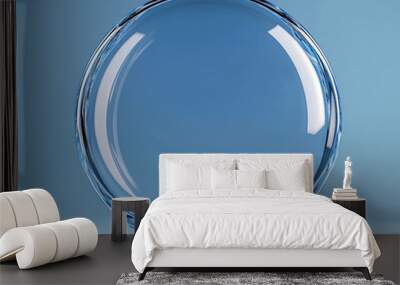 Clear glass ball is sitting on a blue background Wall mural