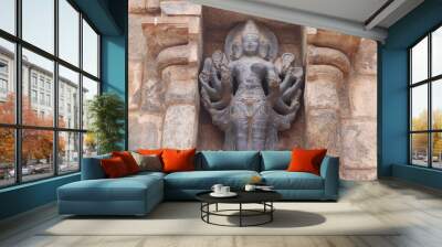 The multi-handed sculpture is carved into a thousand-year-old temple wall. Wall mural