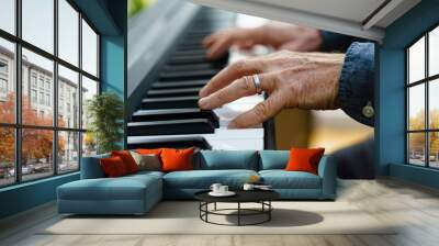 Close-up of an adult man's hands playing a piano Wall mural