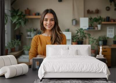 Cheerful woman standing with folded arms in a comfortable, plant-filled office  Wall mural