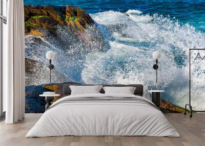 Sea water splashing and foam after wave crashes against the rock Wall mural