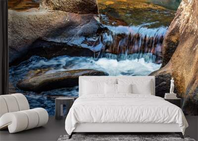 Small river and waterfall with water flowing between the rocks Wall mural