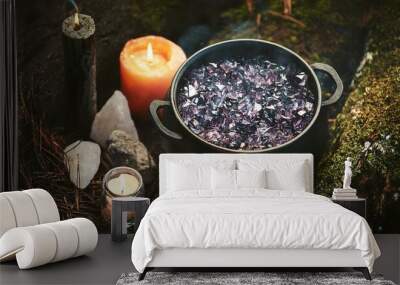 witch cauldron black candle and crystals in forest dark natural background occult esoteric spiritual practice magic ritual witchcraft fairytale mystery atmosphere top view Wall mural