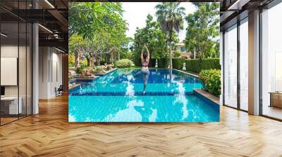 Asia woman doing yoga fitness exercise for relax and healthy beside swimming pool background.  Healthy Concept. Wall mural