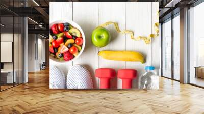 Healthy lifestyle for women diet with dumbbells sport equipment, sneakers, measuring tape, fruit healthy green apples and bottle of water on wooden.  Healthy Concept. Wall mural