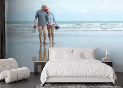 Lifestyle asian senior couple happy walking hug and relax on the beach.  Tourism elderly family travel leisure and activity after retirement in vacations and summer. Wall mural