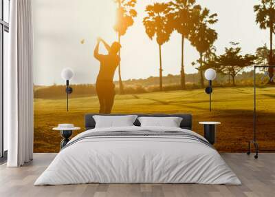 Silhouette Professional Golfer asian man swing and hitting golf ball practice at golf driving range and fairway in sunny morning day on multiethnic club golf. Lifestyle and Sport Concept Wall mural