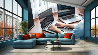 Asian programmer woman looking on multiple computer screen to typing coding database and development website Wall mural