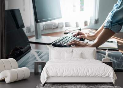 Asian woman programmer is writing code data with keyboard on laptop for new website or applications Wall mural