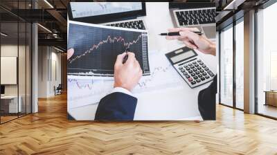 Business team two colleagues working with computer, laptop, discussing and analysis graph stock market trading with stock chart data, financial and investment concept Wall mural