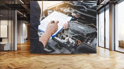 Services car engine machine concept, Automobile mechanic repairman checking a car engine with inspecting writing to the clipboard the checklist for repair machine, car service and maintenance Wall mural