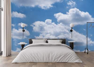 Cumulus clouds are illuminated by the bright sun on a blue sky background. Wall mural