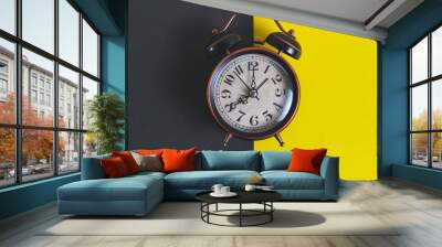 Old retro alarm clock on a yellow and black background. Wall mural