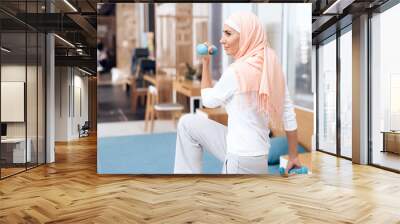 Arab woman doing gymnastics in the bedroom. Wall mural