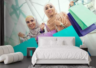 Young Arabian Women with Packages Standing in Mall Wall mural