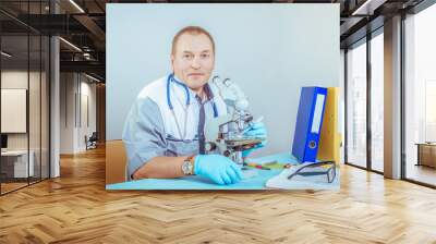 Portrait of a male doctor with a microscope in a laboratory Wall mural