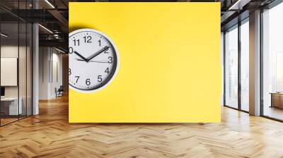 Circular white clock on yellow wall background Wall mural