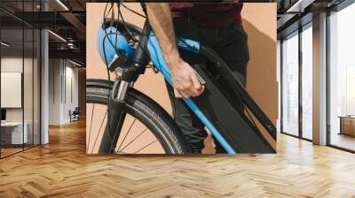 Close up cyclist securing e-bike battery Wall mural