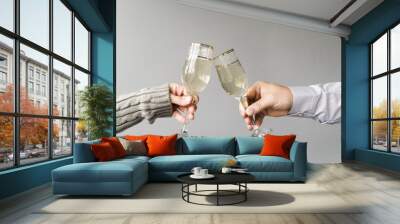 Man and woman toasting champagne flute over grey backdrop Wall mural