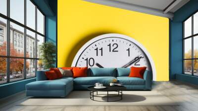 Round clock face against yellow backdrop Wall mural