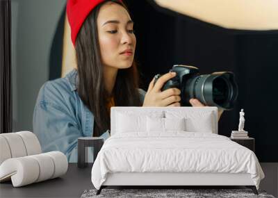 Professional photographer with camera. Asian woman in photography studio. Wall mural