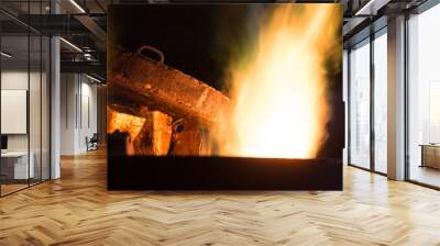 Steel worker in protective clothing raking furnace in an industr Wall mural