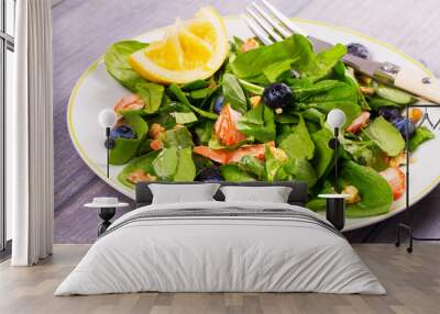 Salmon, spinach, blueberries and walnuts salad on white plate Wall mural